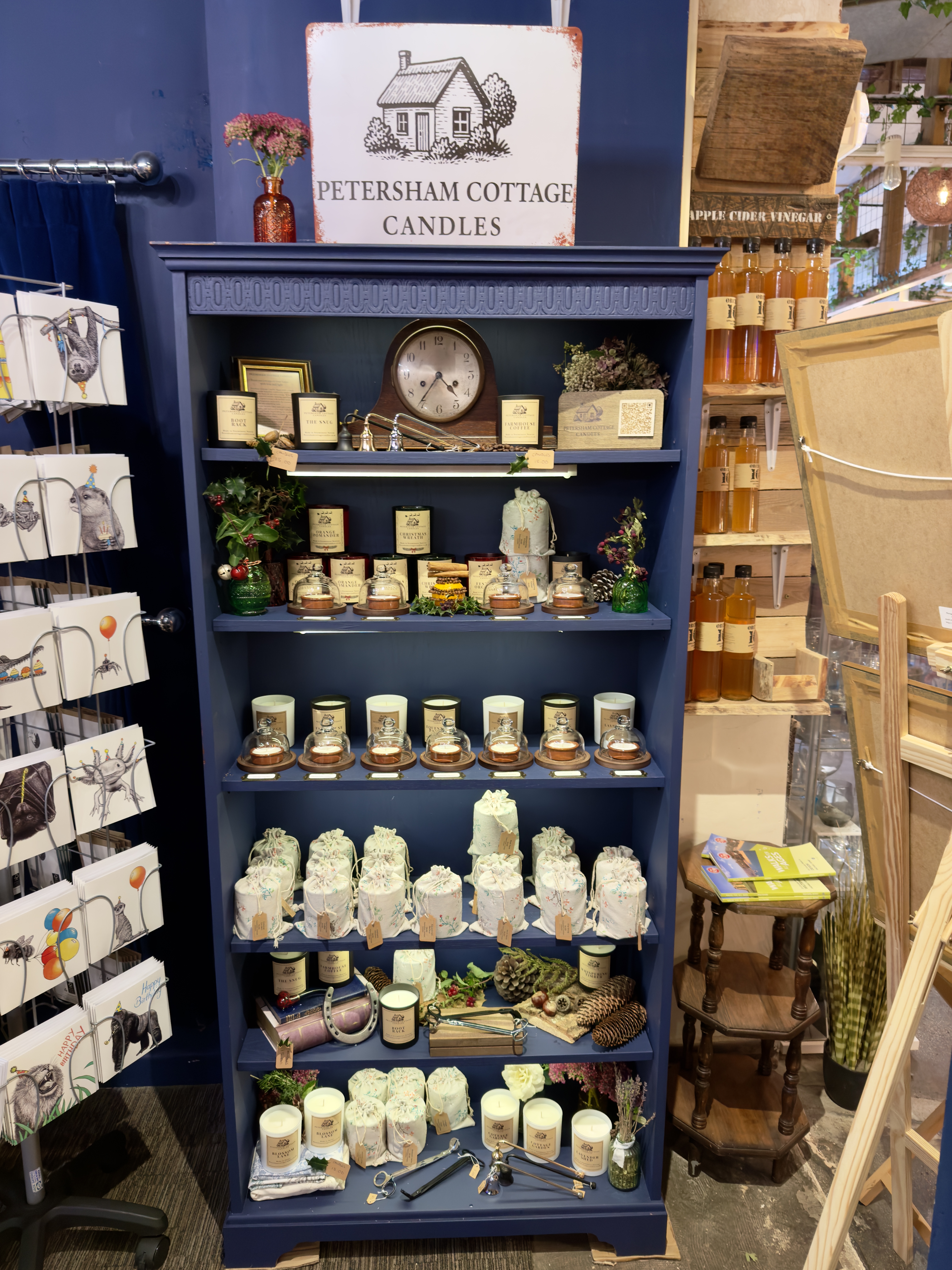 Petersham Cottage Candles arranged on a bookshelf display at 1855 in Sturminster Newton, Dorset