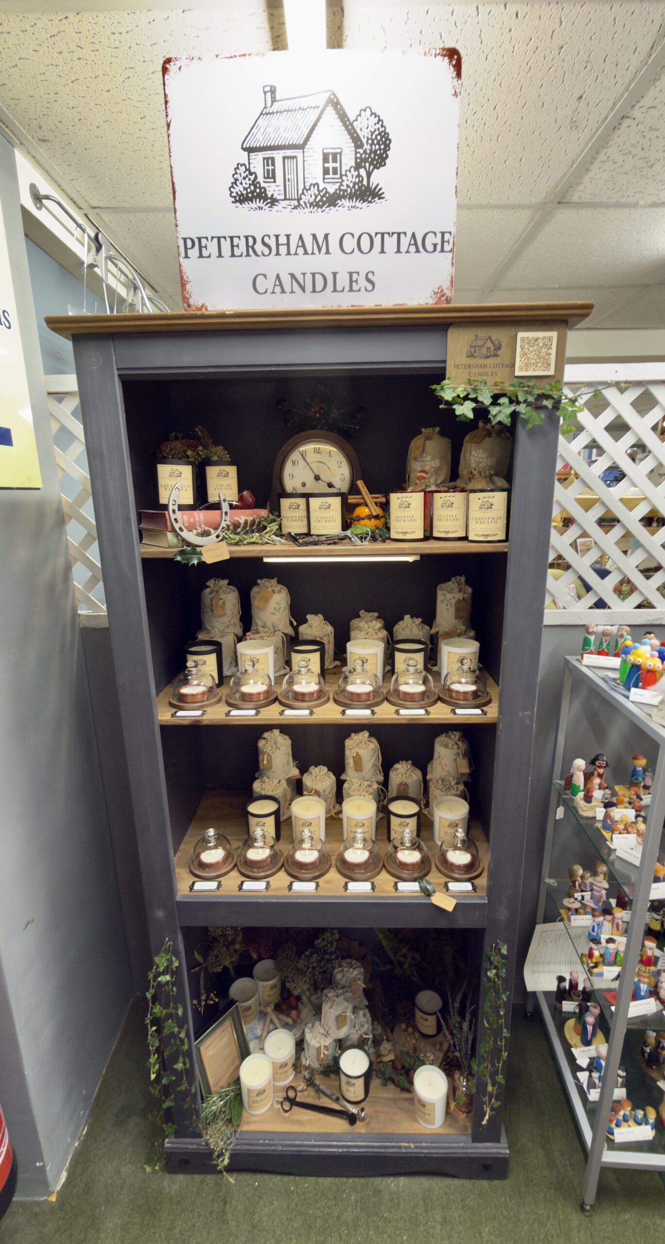 Handmade Petersham Cottage Candles display at The Emporium in Yeovil, featuring cottage-style candles and linen bags on wooden bookshelf