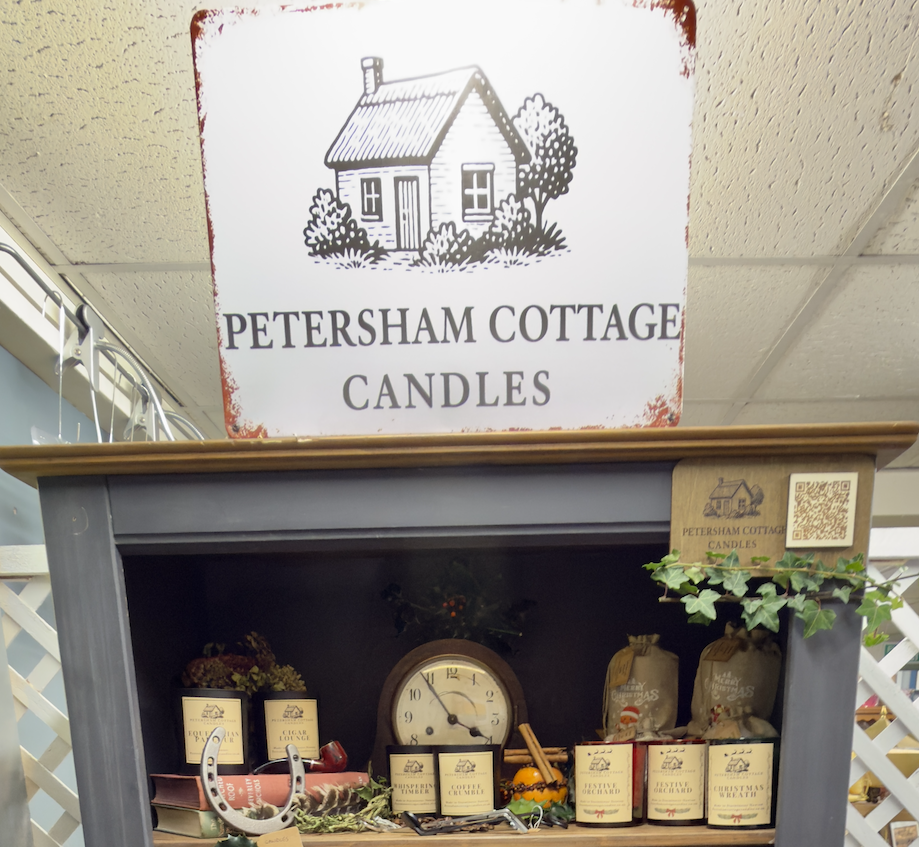 Handmade Petersham Cottage Candles display at The Emporium in Yeovil, featuring cottage-style candles and linen bags on wooden bookshelf