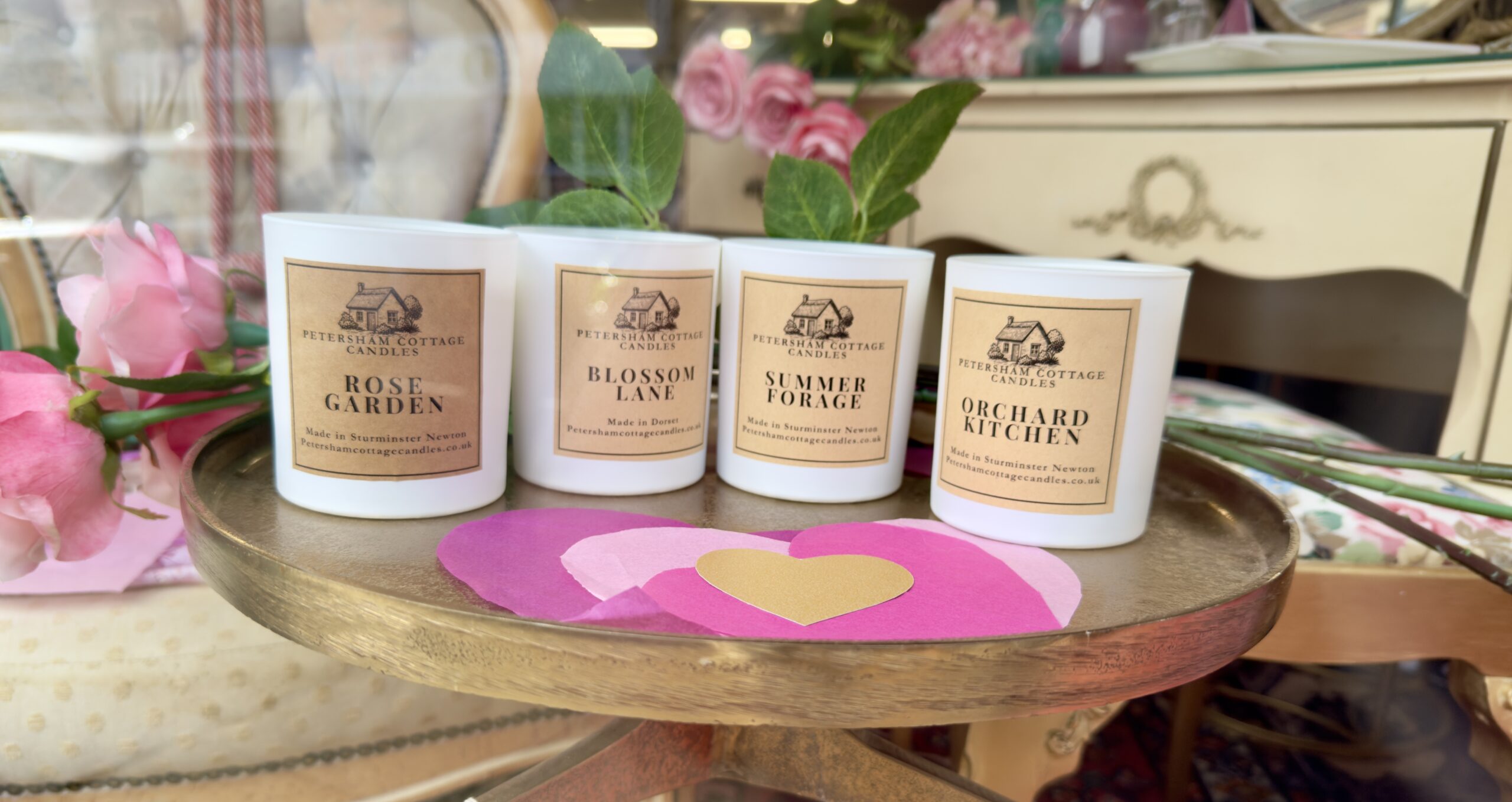 Close-up of Petersham Cottage Candles in a Bridgerton-inspired Valentine’s window display, featuring Rose Garden, Blossom Lane, Summer Forage and Orchard Kitchen candles.